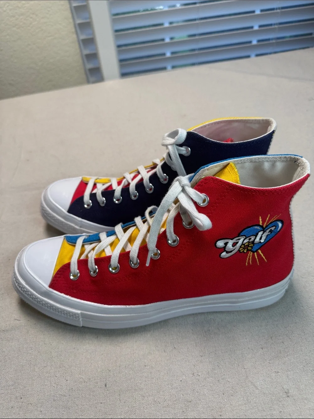 Converse All Star Chuck Golf Wang High Top Sneakers in Yellow, Blue, and Red.